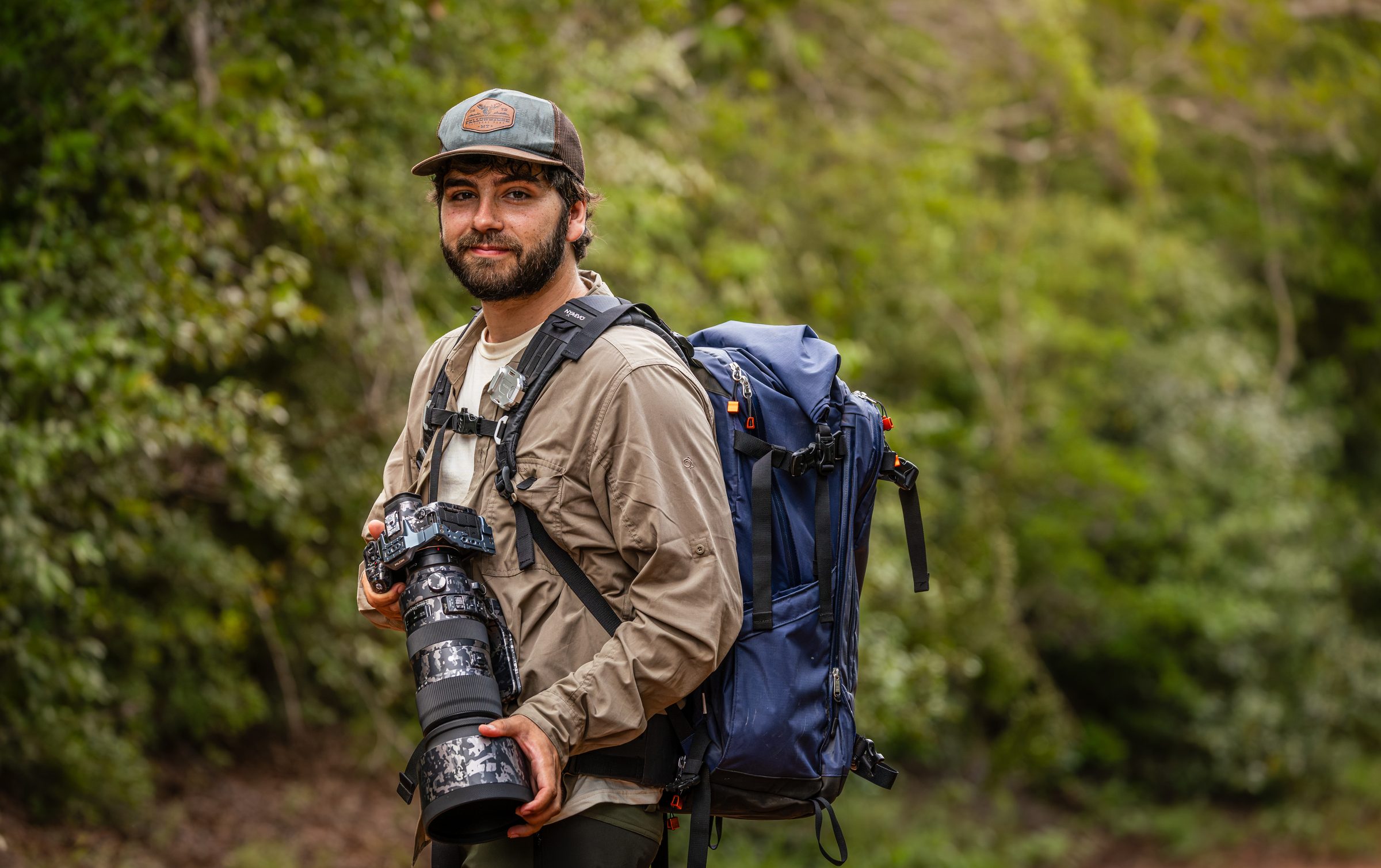 Greg con su cámara y teleobjetivo en el bosque