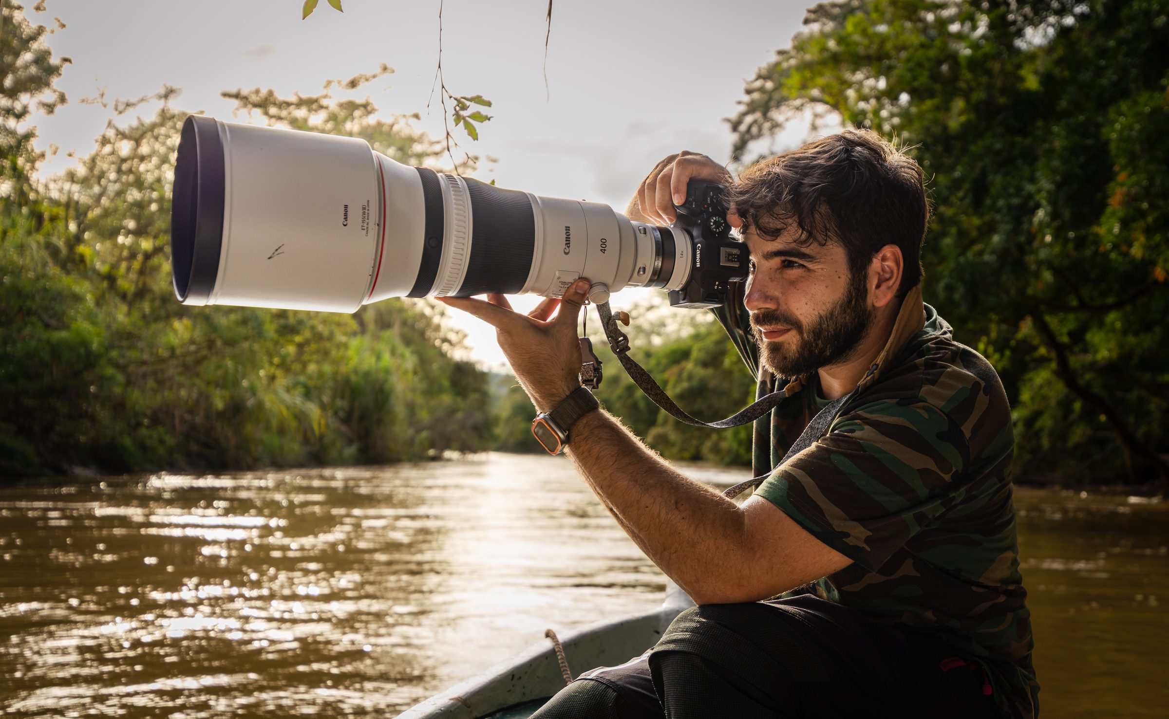 Greg fotografiando desde una barca en un río